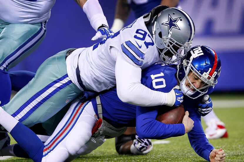 Dallas Cowboys defensive tackle Jason Hatcher (97) takes down New York Giants quarterback...