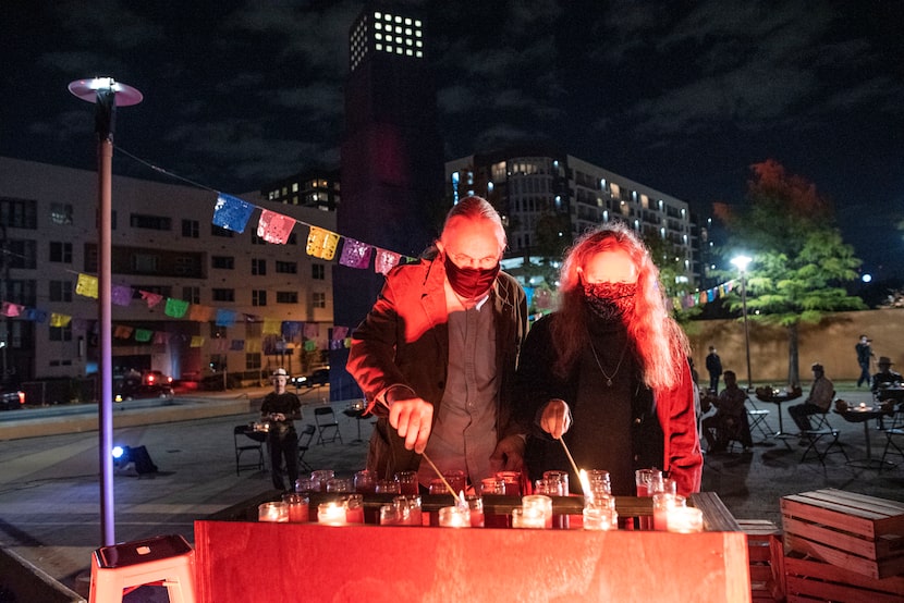 John Fullinwider and Sandy Rollins light candles for loved ones who have died, before the...