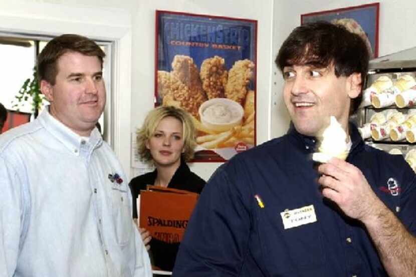 Dallas Mavericks owner Mark Cuban serves up a soft-serve cone to the approval of DQ Manager...