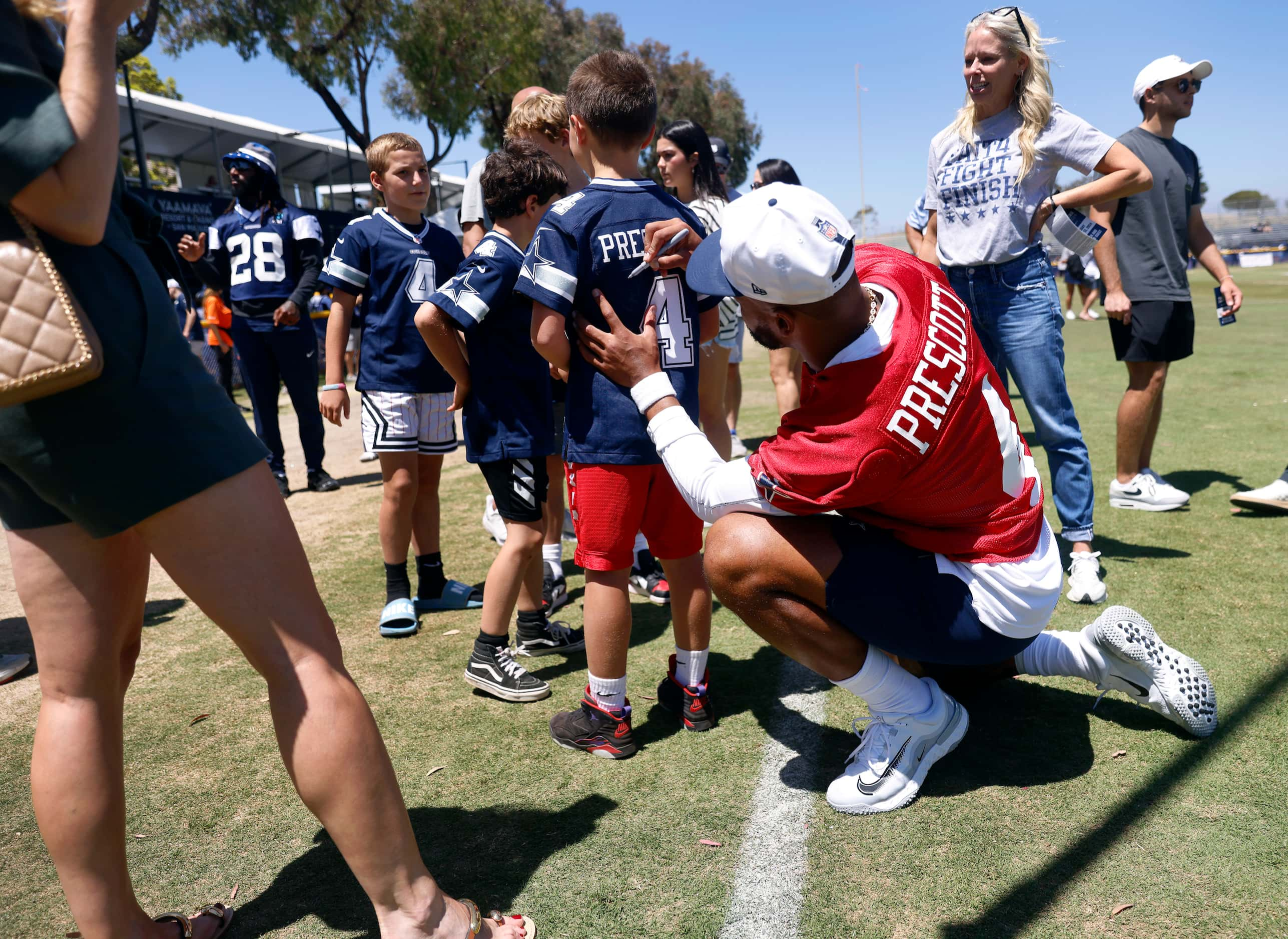 Dallas Cowboys quarterback Dak Prescott signs jerseys for young fans following a mock game...