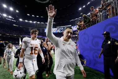 Texas Longhorns head coach Steve Sarkisian waves to fans as he and backup quarterback Arch...