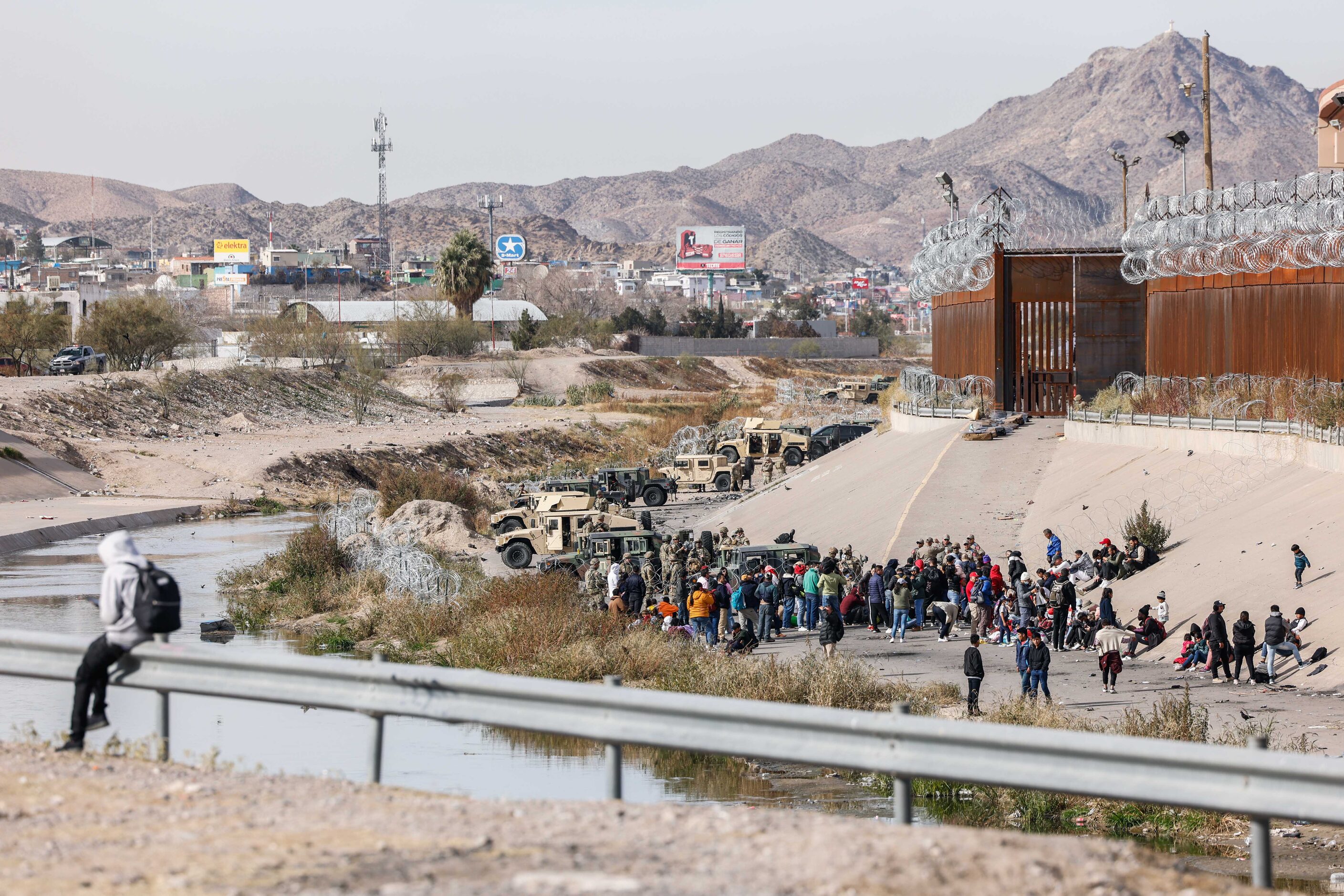 Migrants start to gather close to where the end of Texas National Guards are deployed at...