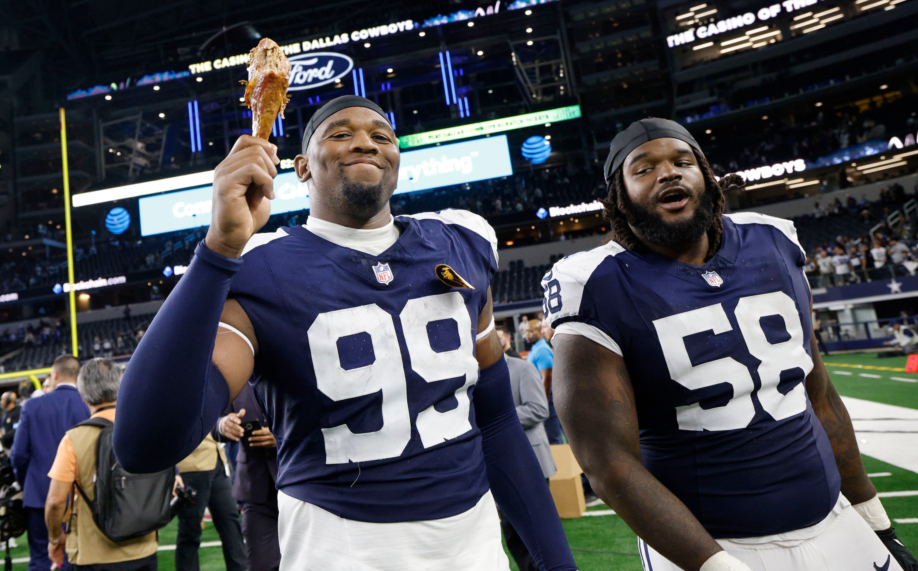 Dallas Cowboys defensive end Chauncey Golston (99) holds up a turkey leg when he leaves the...