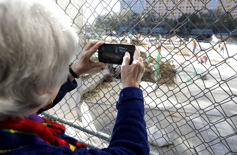 Mary Higbie photographs the "Mustangs of Las Colinas" sculpture at the Towers at Williams...