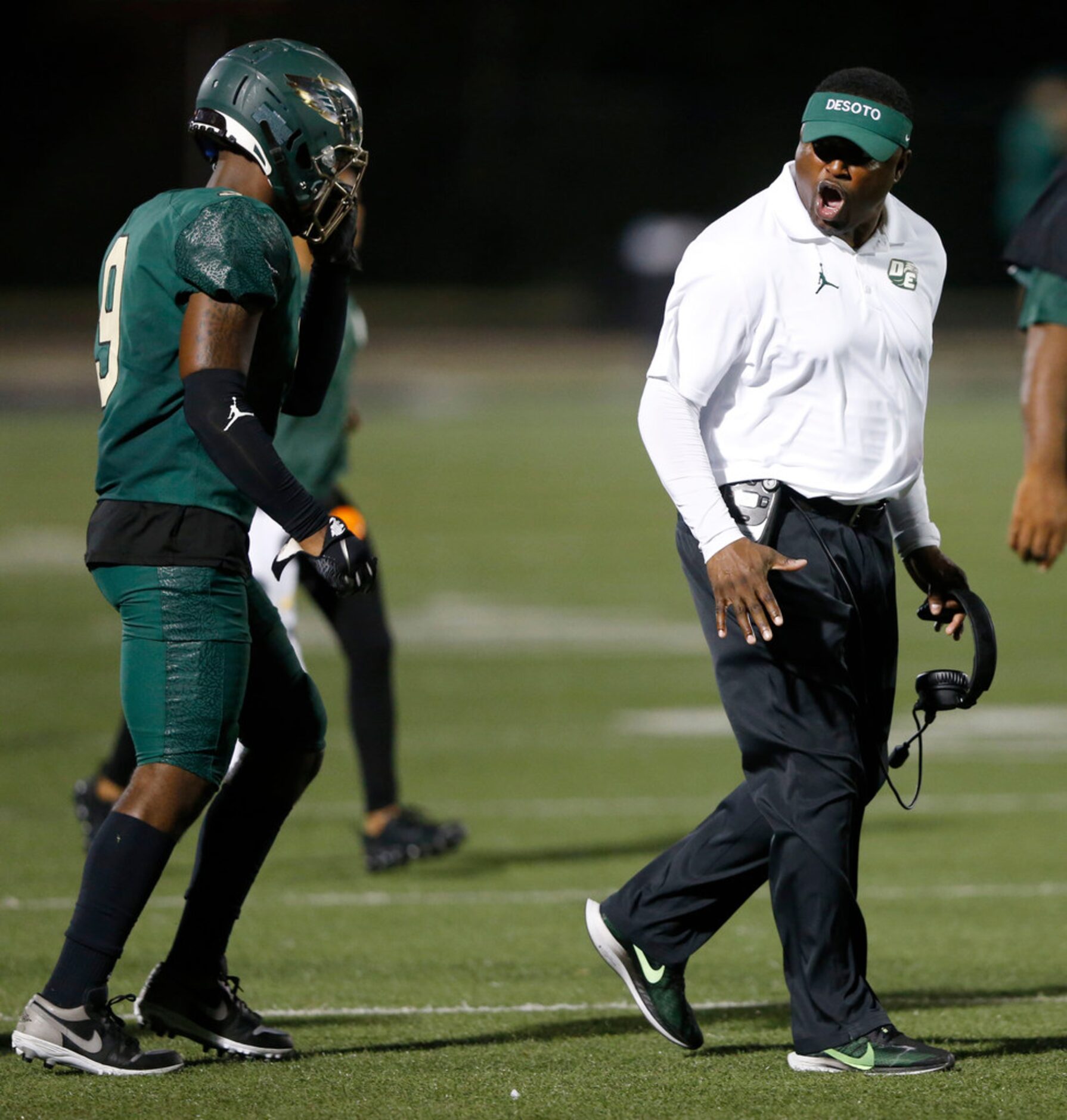 DeSoto head coach Claude Mathis talks to DeSoto's Ridarius Branch (9) during the first half...