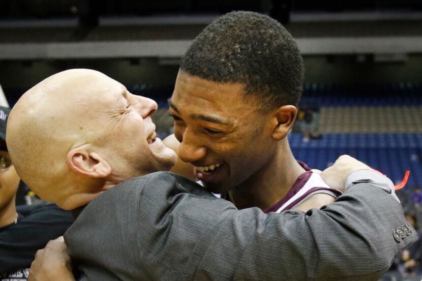 Head coach Duane Gregory hugs Mansfield Timberview's Chris Mullins (24) at the end of the...