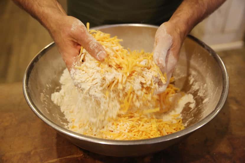 Chef Robert Lyford combines ingredients while preparing cheddar biscuits at Patina Green...