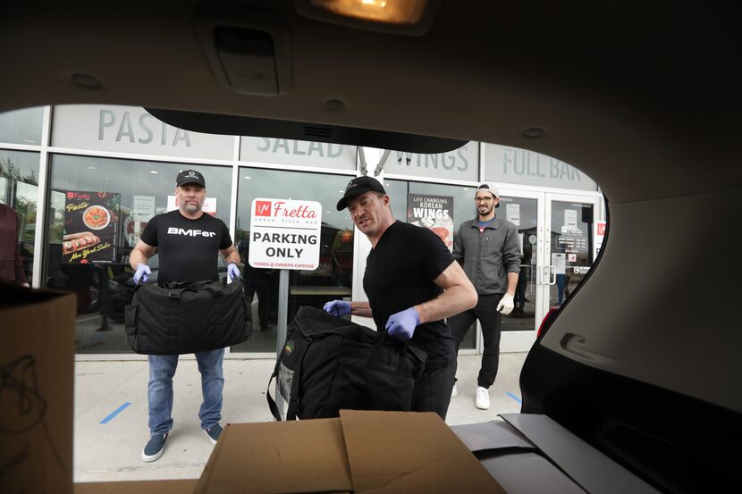 Jeremy Soder, a volunteer from Body Machine Fitness, loads freshly prepared meals into a...