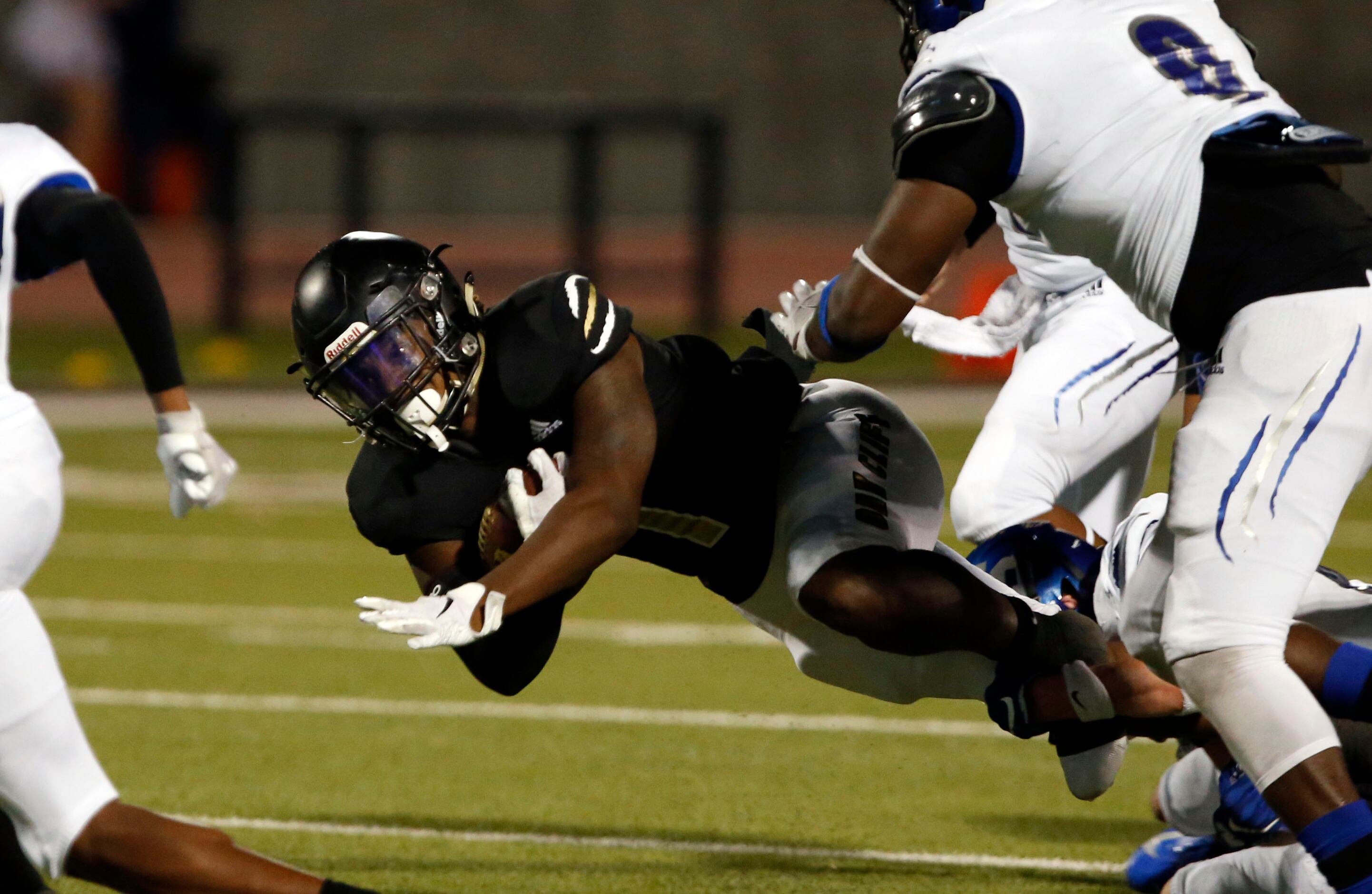 South Oak Cliff’s Mikeviun Titus (1) dives for a couple of yards during the first half of...
