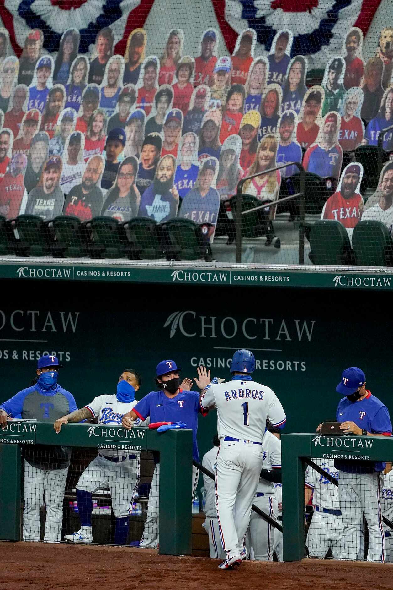 Texas Rangers shortstop Elvis Andrus celebrates with teammates after scoring on a single by...