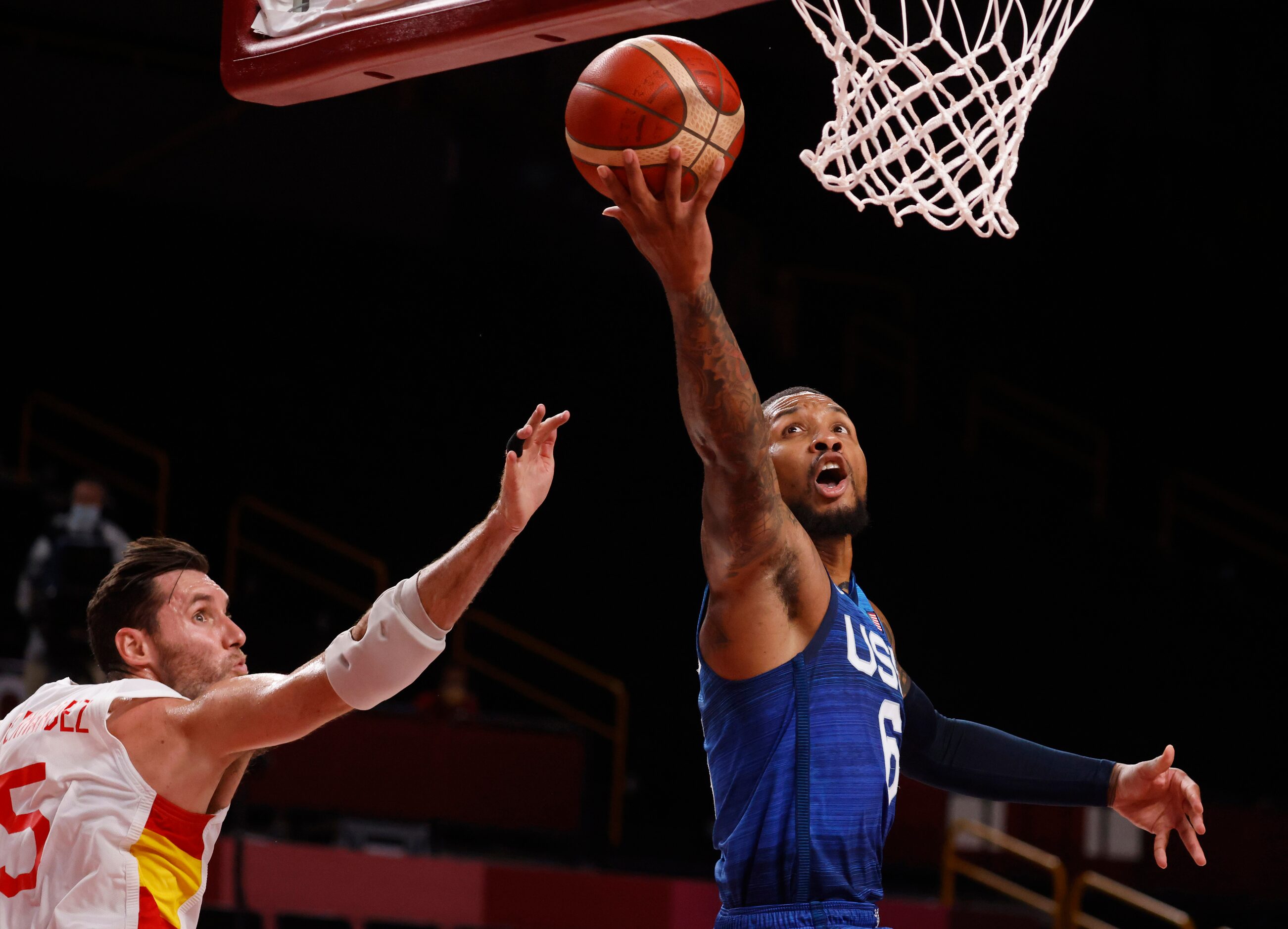 USA’s Damian Lillard (6) attempts a layup in front of Spain’s  Rudy Fernandez (5) during the...