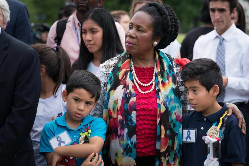 Rep. Sheila Jackson Lee of Houston stands with young relatives of immigrant rights activists...
