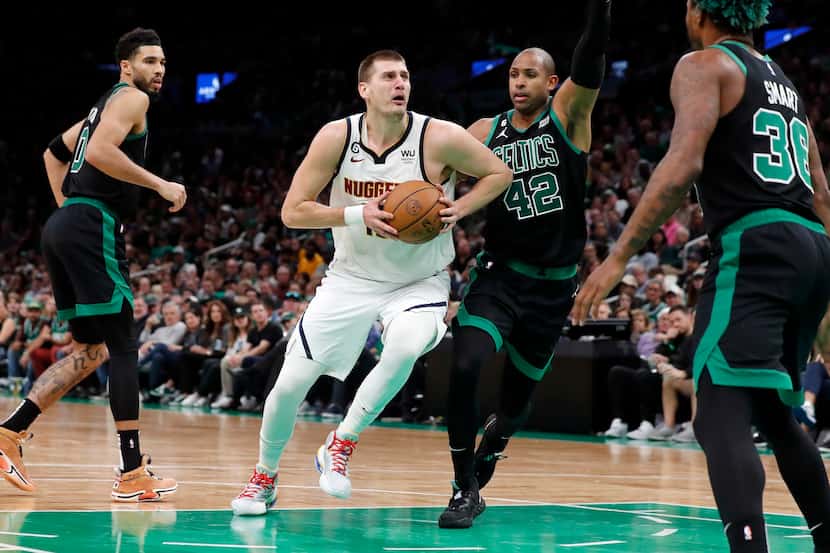Denver Nuggets' Nikola Jokic, center left, drives past Boston Celtics' Al Horford (42)...