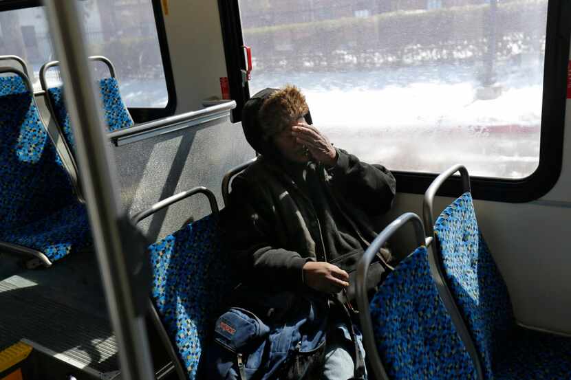  Artis Frank rubs his face while riding a DART bus during the last leg of his long daily...