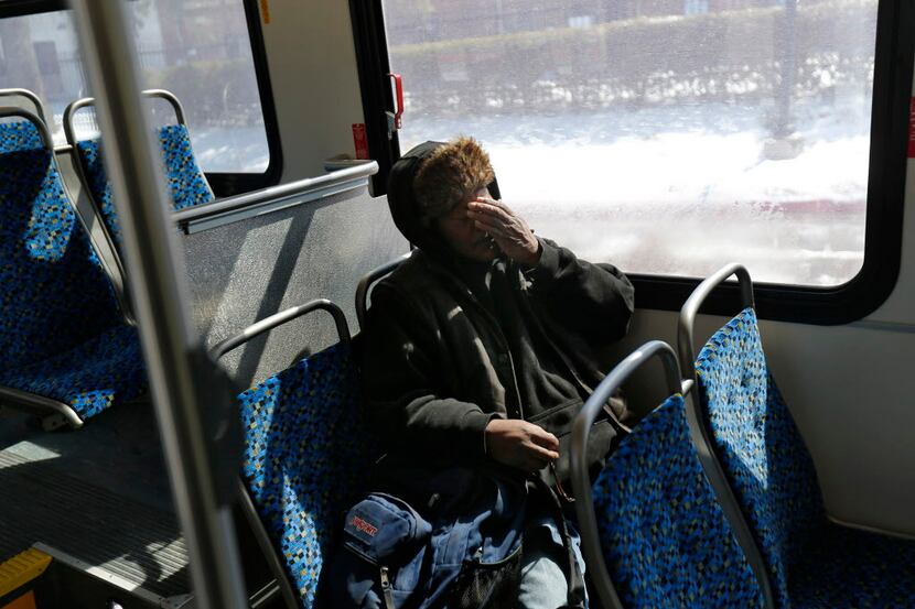  Artis Frank rubs his face while riding a DART bus during the last leg of his long daily...