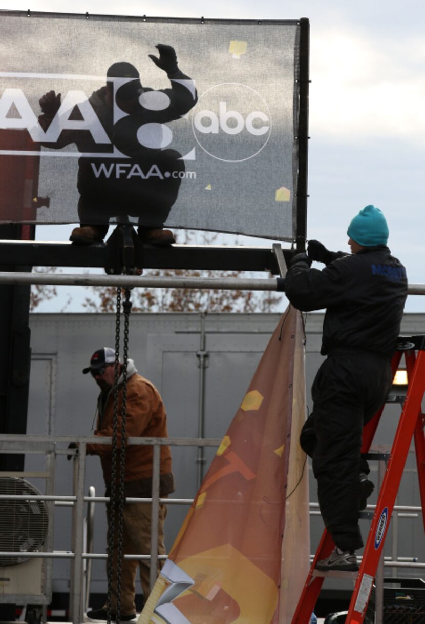 Jonathan Jones (top), David Hope (right) and Dwayne Buchanan hang up signs for the Big D NYE...