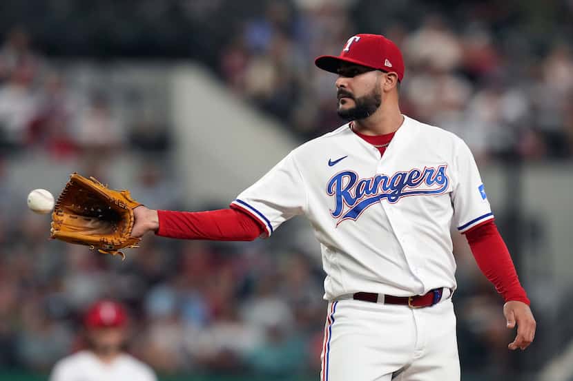 Texas Rangers starting pitcher Martin Perez is tossed a new game ball during the second...