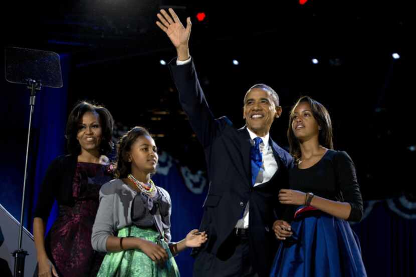 President Barack Obama waves as he walks on stage with first lady Michelle Obama and...