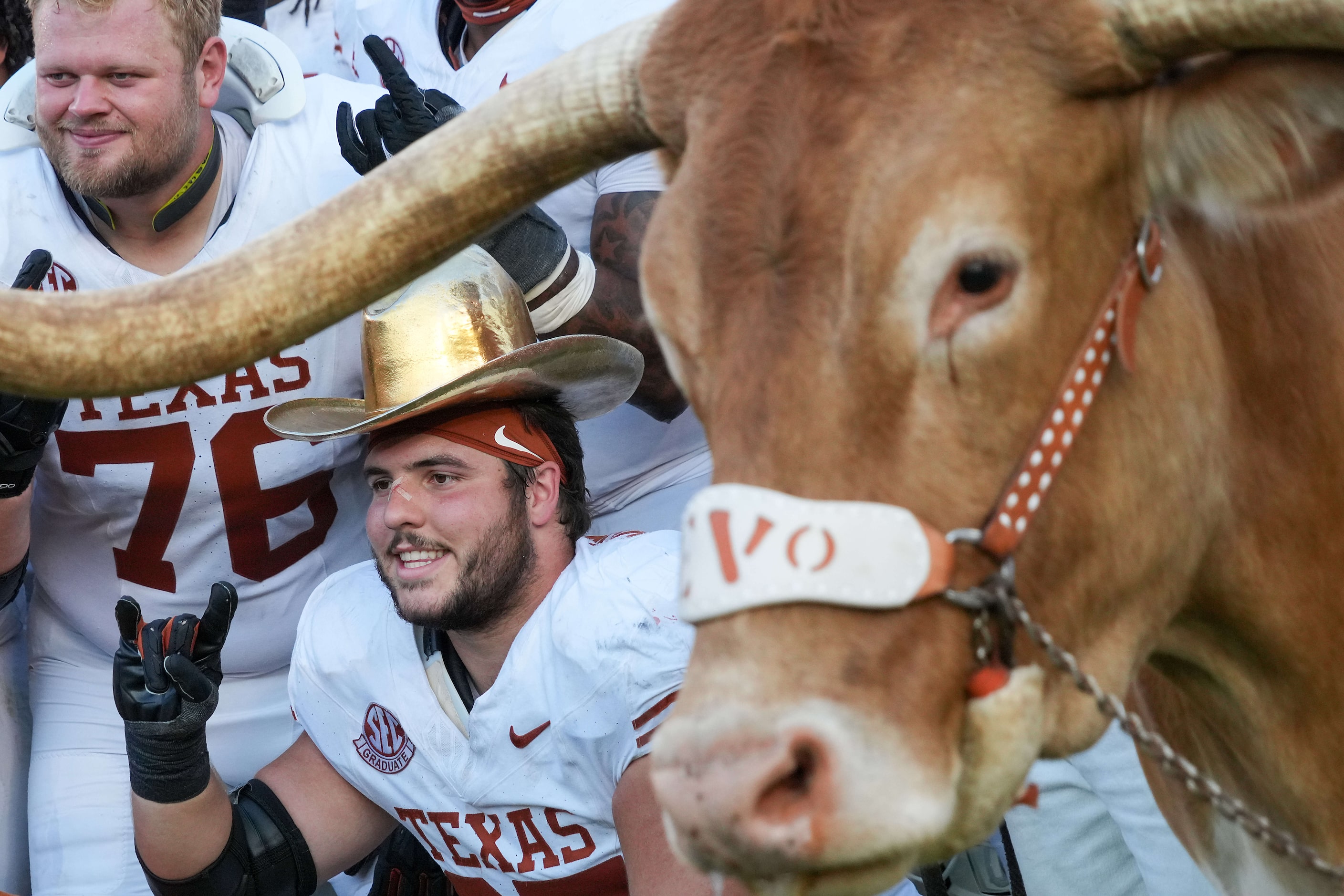 Texas offensive lineman Jake Majors wears the Golden Hat Trophy as he poses with offensive...