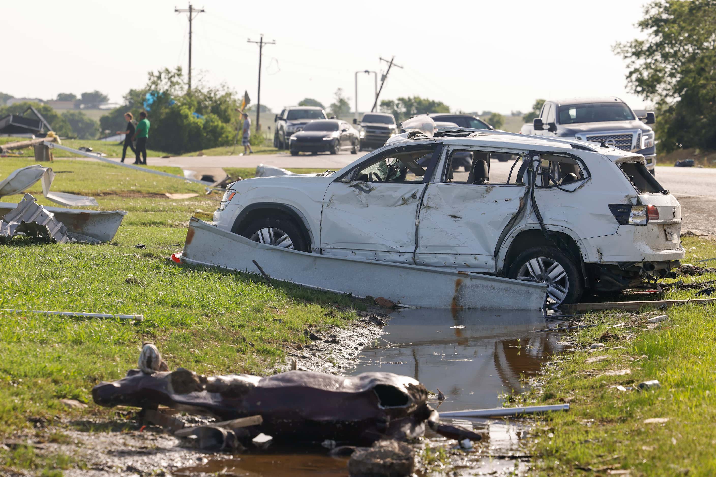 A damaged car remains on the side of the road by a Shell gas station, on Sunday, May 26,...