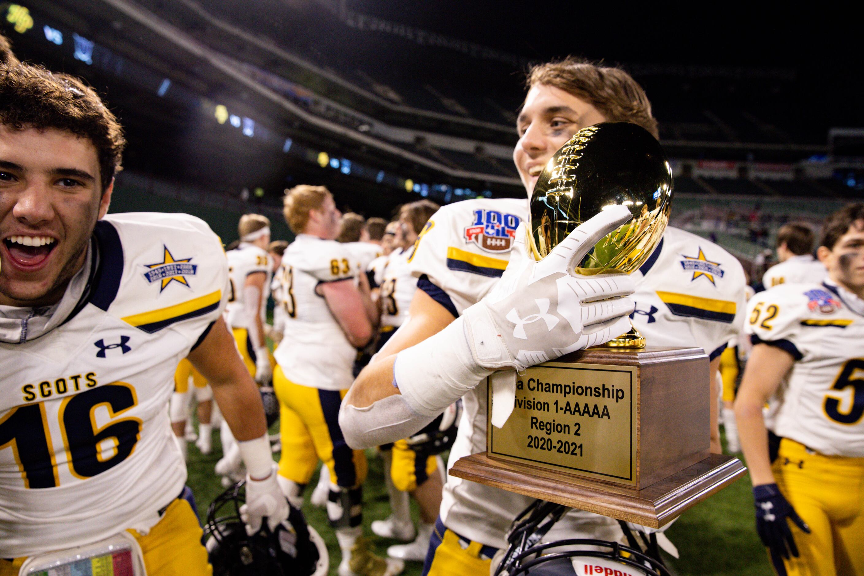 Highland Park's Luke Rossley (26) holds the trophy after winning a Class 5A Division I...