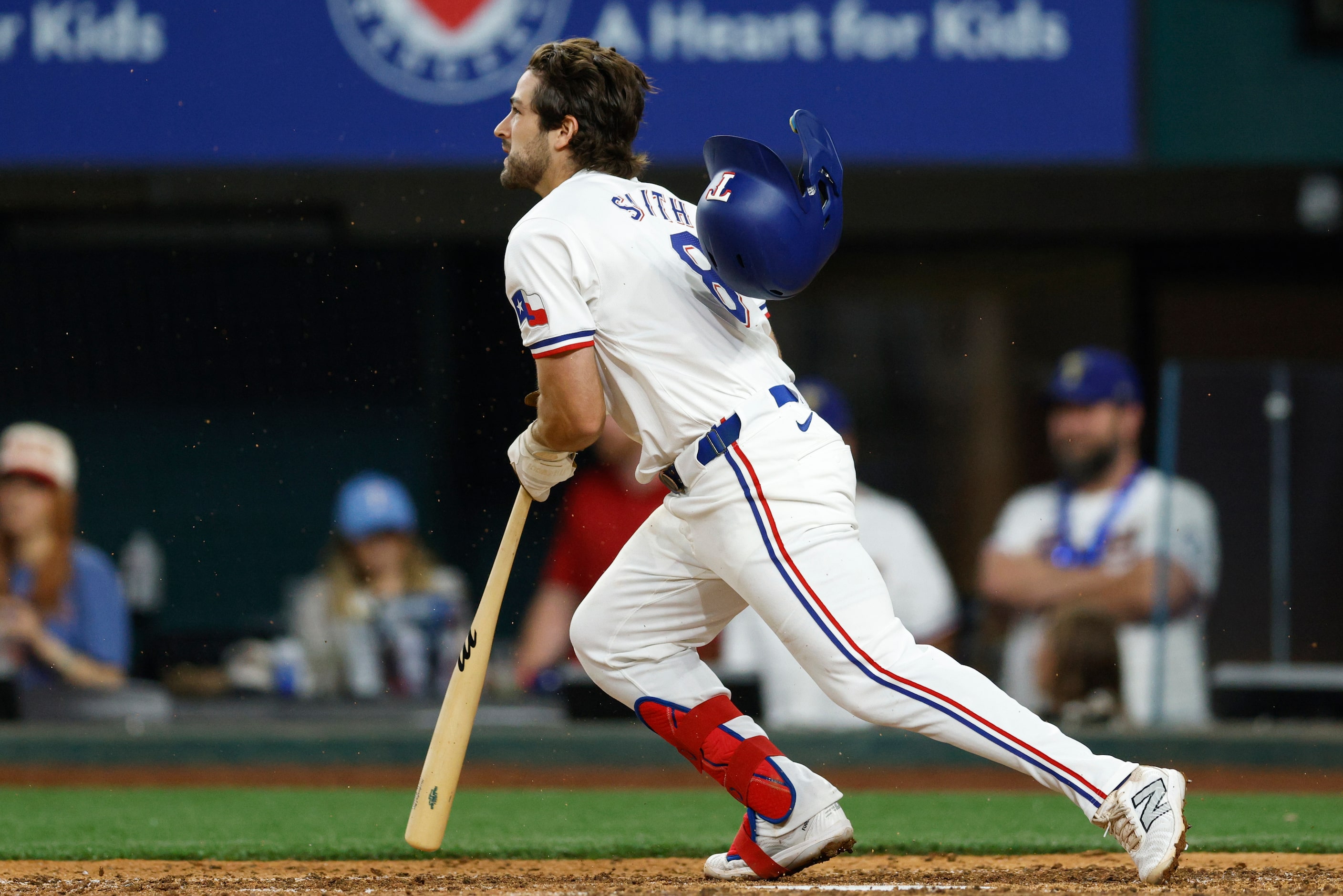 Texas Rangers third baseman Josh Smith (8) runs to first as his helmet falls off during the...