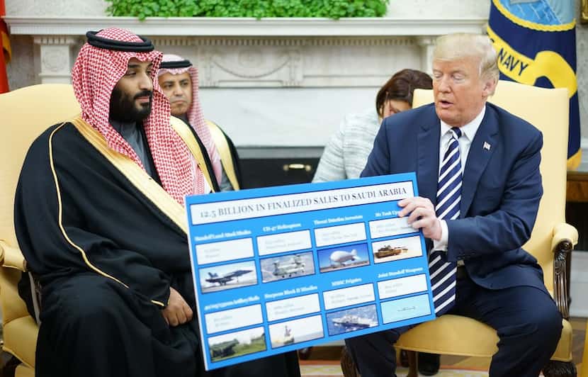 President Donald Trump holds a defense sales chart with Saudi Arabia's Crown Prince Mohammed...