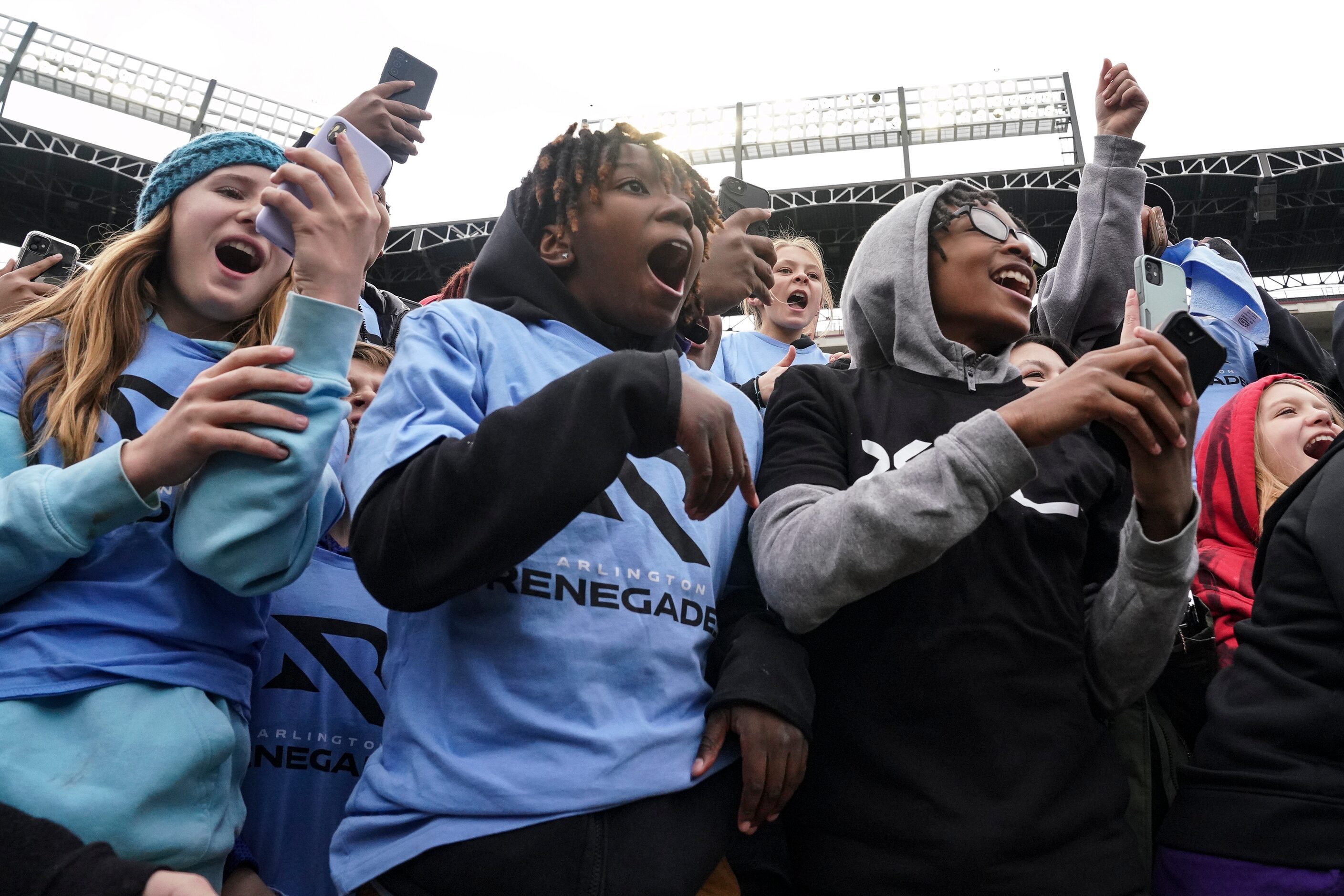 Kids in the crowd record videos and cheer as Dwayne “The Rock” Johnson stands in front of...