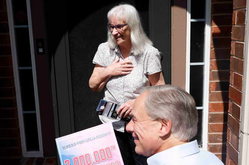 Gov. Greg Abbott interacts with Maggie Pitka of Allen, homeowner of the 2 millionth door the...