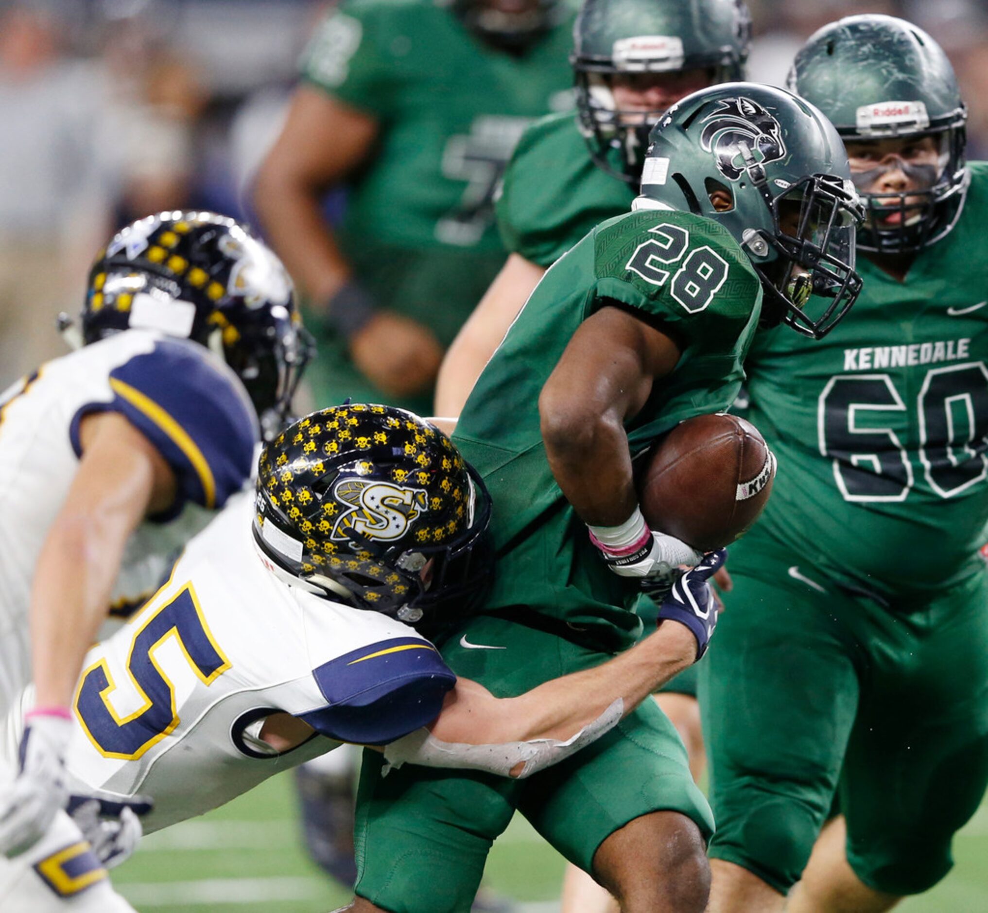 Stephenville's Gage Graham (25) forces Kennedale's DJ Kirven (28) to fumble during the first...