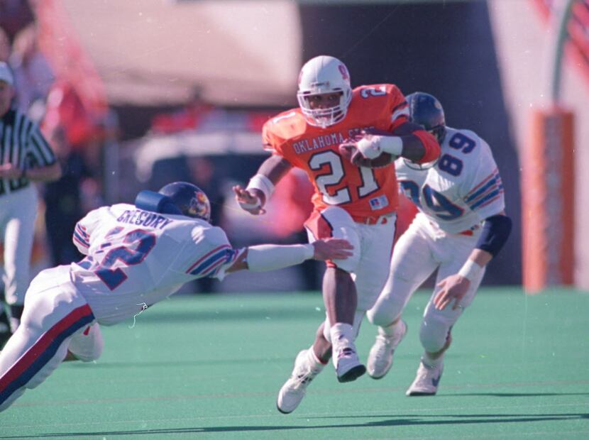 Kansas defenders Troy Gregory (12) and Jason Tyrer (89) try to tackle Oklahoma State...