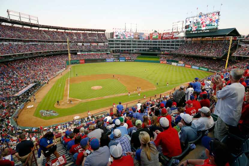 Texas Rangers fans cheer as the Texas Rangers finish an inning in a game against the...