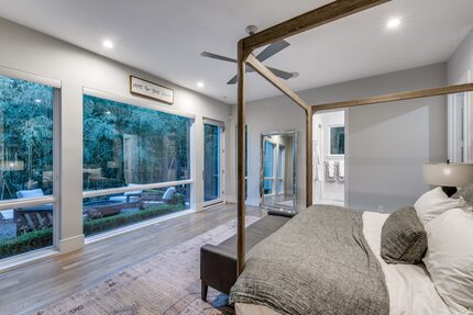 The primary bedroom looks out to a fire pit seating area.