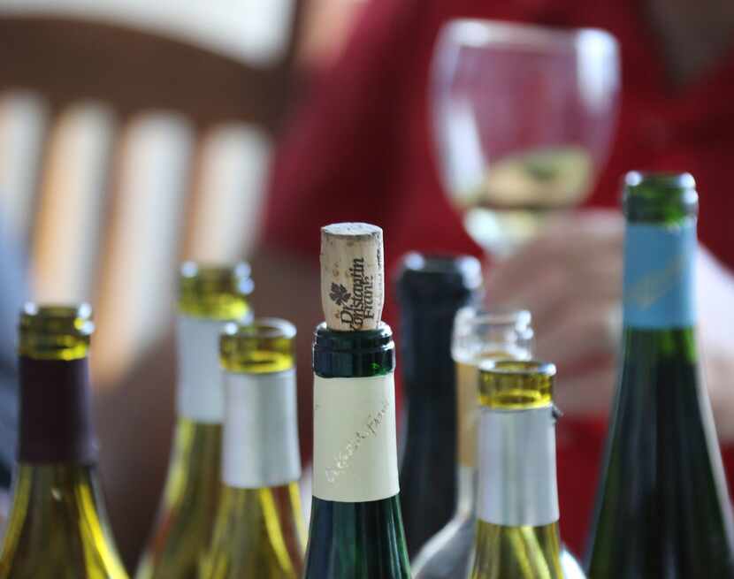 Wine bottles sit open on the table 