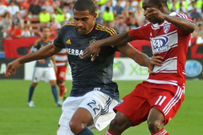 FC Dallas' Fabian Castillo (11) and LA Galaxy's Leonardo (22) battle for the ball during a...