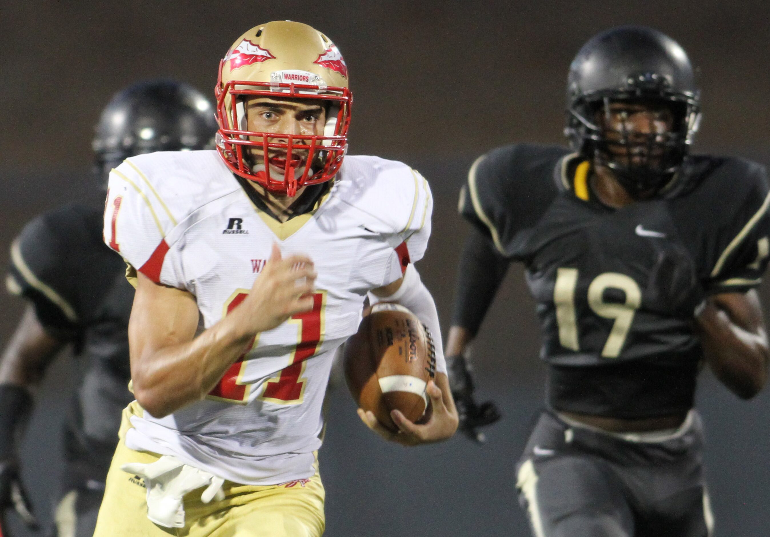 South Grand Prairie quarterback Greg Eisworth (11) is "off to the races" as he scampers...