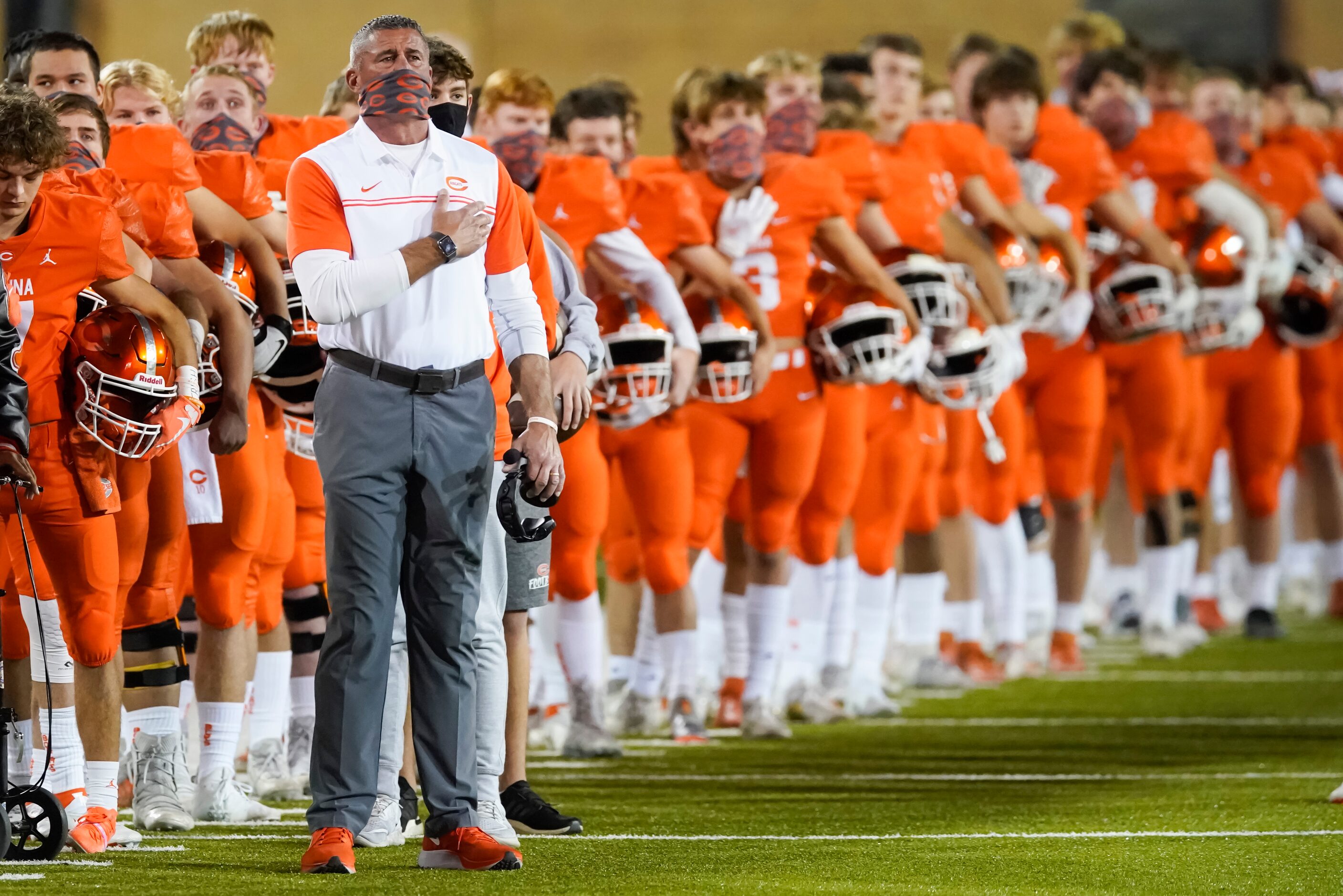 Celina head coach Bill Elliott stands for the national anthem with his team before a Class...