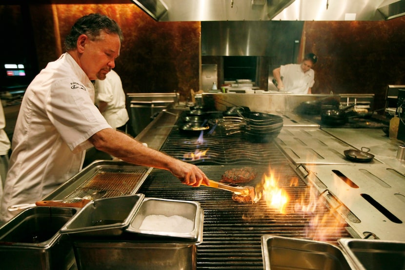 Chef Stephan Pyles grills a cowboy rib-eye steak while working the kitchen in the restaurant...