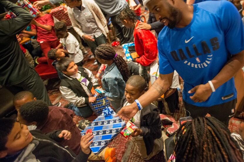 Mavericks players including Wesley Matthews (right) hand out a gift at the Mavericks annual...