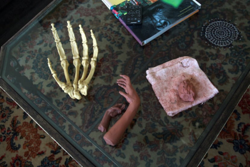 On the living-room coffee table, various hands, and a mound of clay that may one day be a...