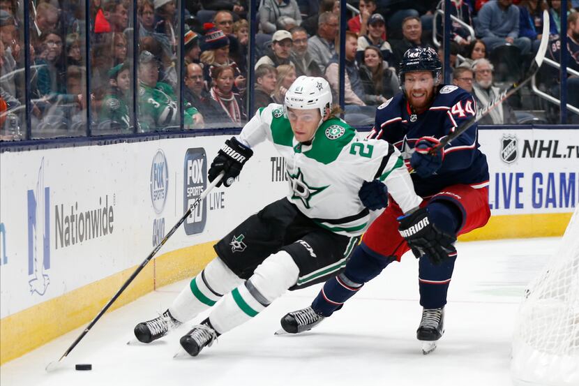 Dallas Stars' Roope Hintz, left, of Finland, carries the puck behind the net as Columbus...