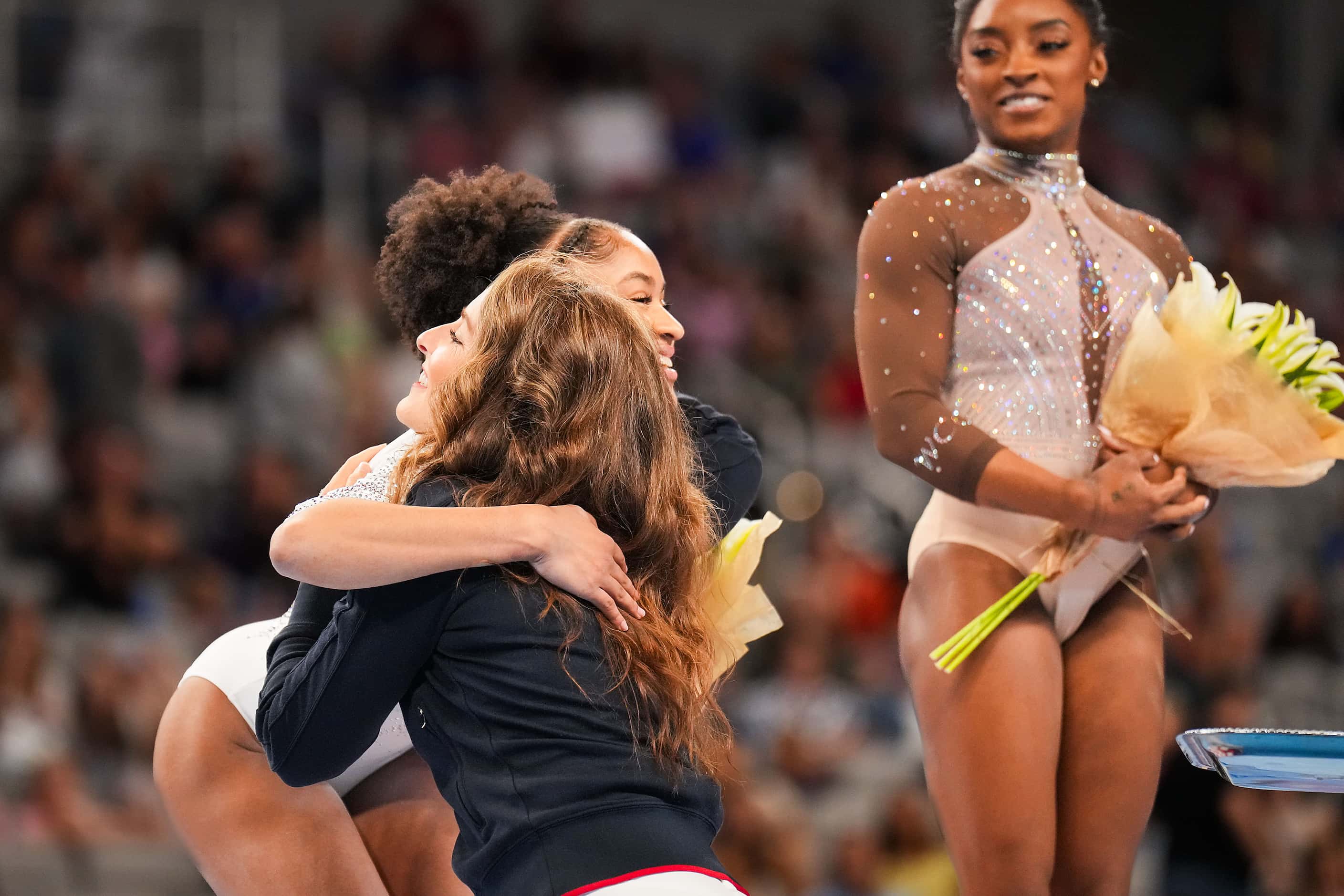 2004 Olympic all-around gold medalist Carly Patterson (facing at left) hugs Skye Blakely...