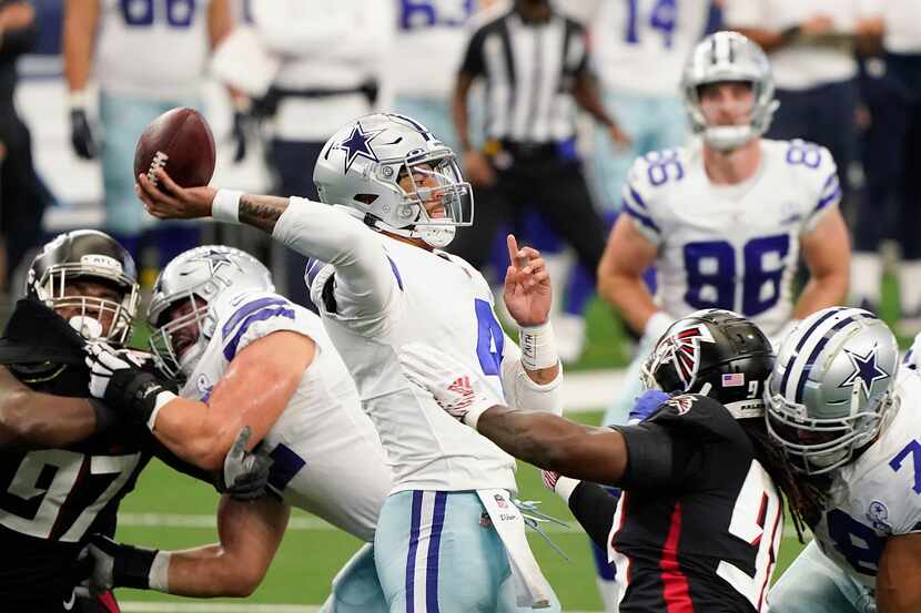 FILE - Cowboys quarterback Dak Prescott (4) throws a pass under pressure in the first...