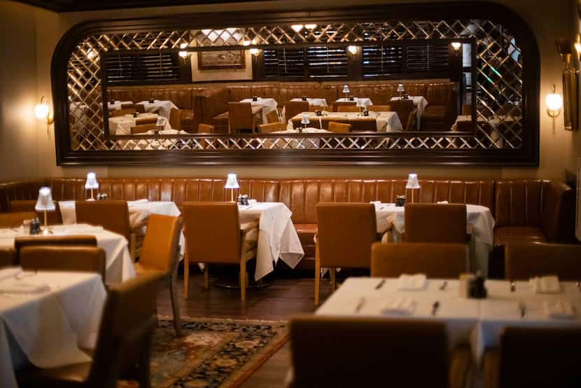 The dining room at NDA Brasserie is split from the bar with a wall of dark-colored shutters...