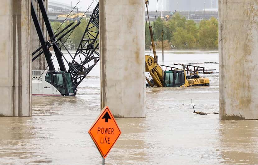 Rising water  in the Trinity River swallowed construction equipment under Interstate 35E on...