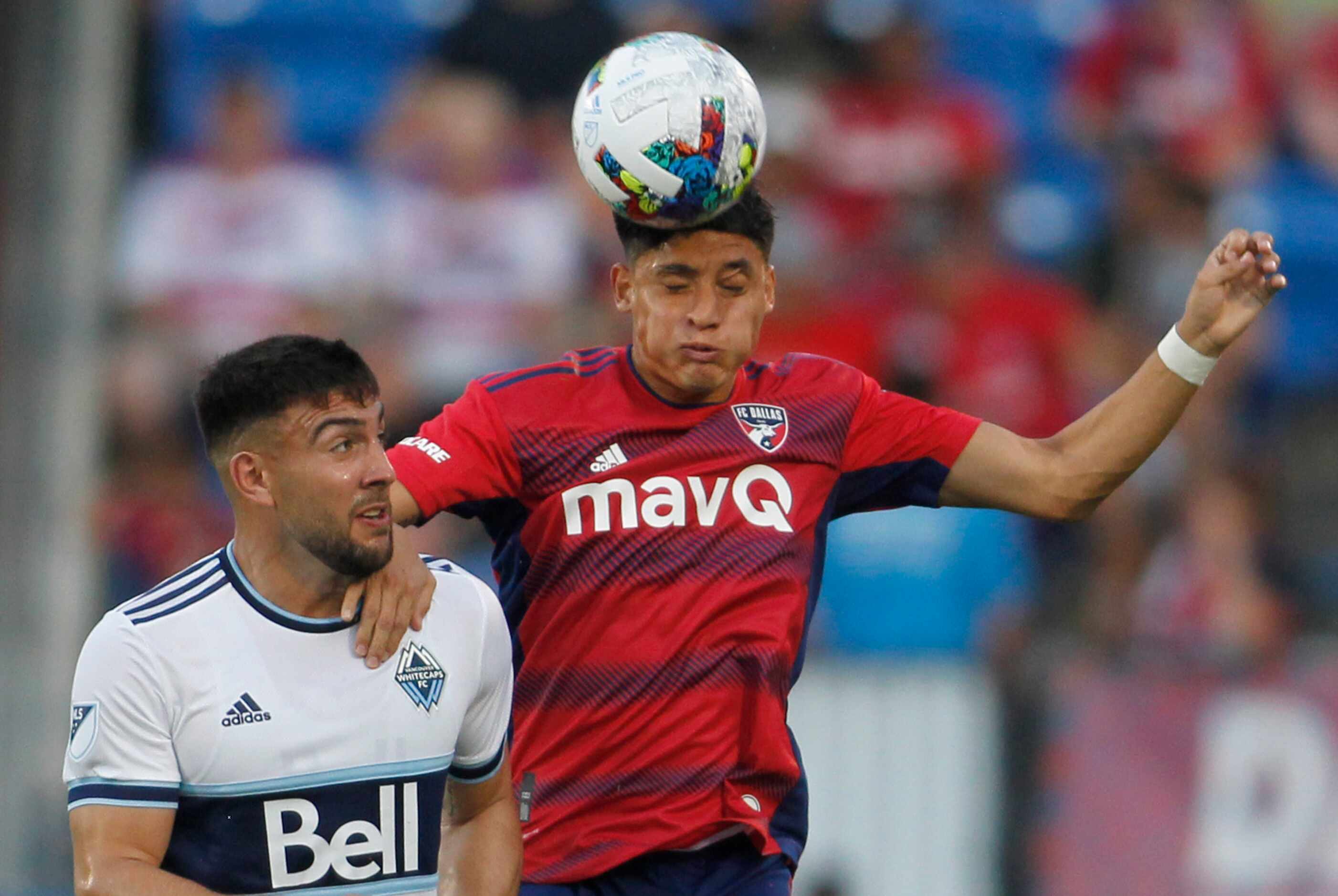 FC Dallas defender Marcus Farfan (4), right, heads the ball away from Vancouver's Lucas...