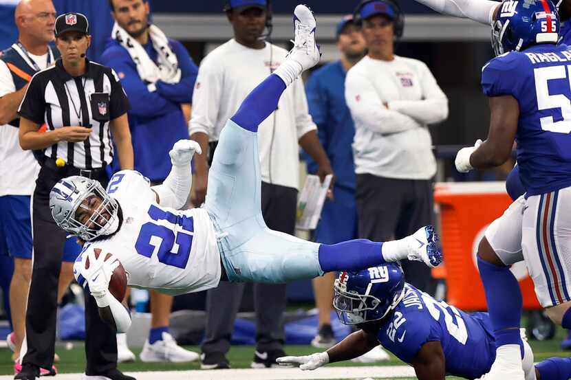 Dallas Cowboys running back Ezekiel Elliott (21) is upended by New York Giants cornerback...