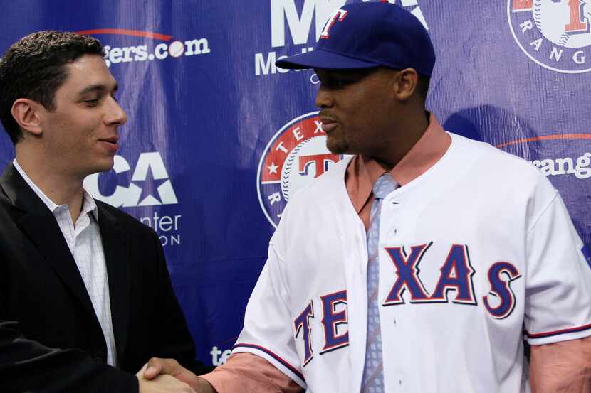 Texas Rangers general manager Jon Daniels shakes hands with newly acquired third baseman...