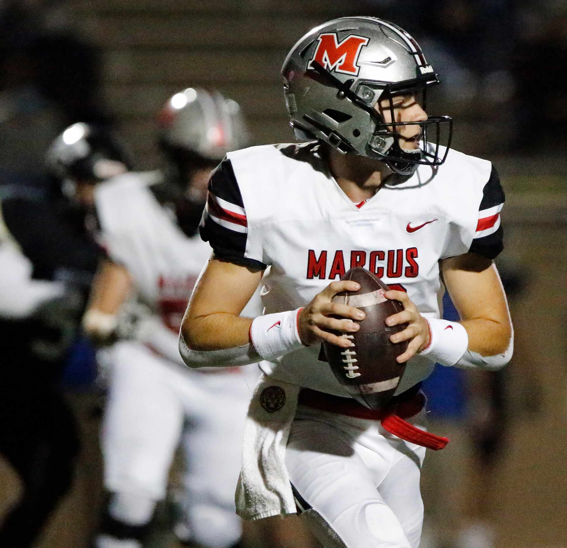 Flower Mound Marcus High School quarterback Garrett Nussmeier (13) scrambles before being...