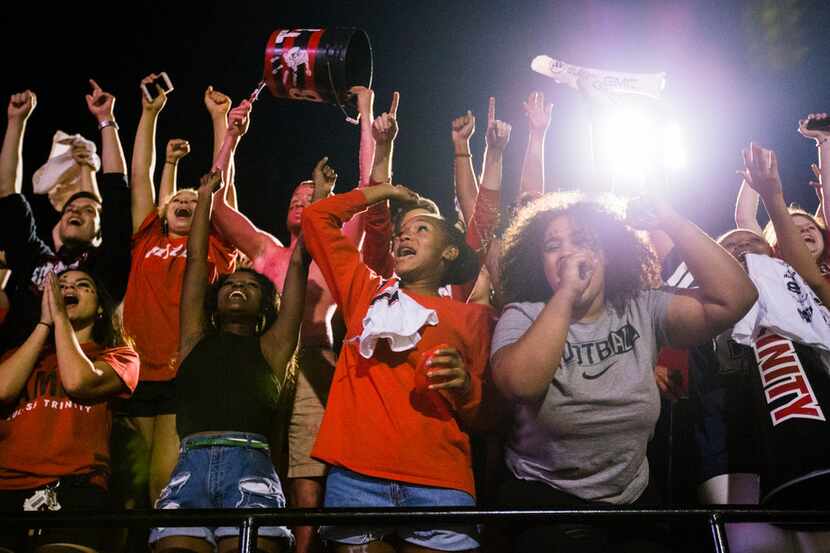 Euless Trinity fans celebrate a touchdown putting them ahead 21-20 during the fourth quarter...